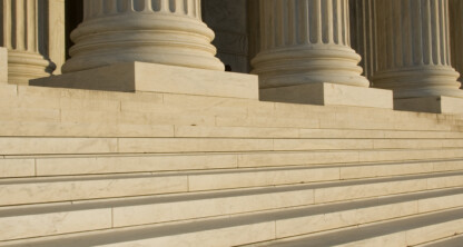 Wide marble steps and large stone columns mark the grand entrance of a corporate law office, reflecting the prestige and tradition of leading lawyers in Chicago.