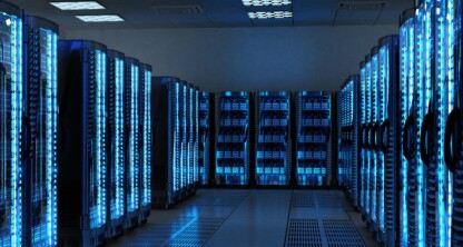 Una sala de centro de datos con varias filas de bastidores de servidores iluminados y luz azul, que recuerda a la infraestructura de alta tecnología que suelen gestionar los bufetes de abogados corporativos o en la que confían los abogados de Chicago para soluciones de datos seguras.