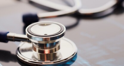 Un estetoscopio apoyado sobre una radiografía en un bufete de abogados especializado en derecho mercantil, que simboliza la colaboración entre los profesionales médicos y los abogados en Chicago.