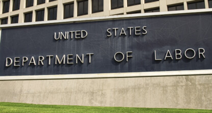 Large sign reading "United States Department of Labor" in front of a government building with multiple windows and a well-kept lawn, frequented by lawyers in Chicago seeking litigation support.
