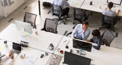 Modern open-plan law offices with chicago lawyers working at desks, using computers and paperwork, set against brick walls and large windows.