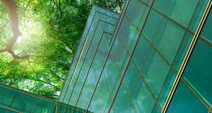Los edificios acristalados reflejan los árboles verdes y la luz del sol, fusionando la vegetación natural con la arquitectura moderna: una vista inspiradora para un bufete de abogados especializado en derecho mercantil o para los abogados de Chicago que buscan un espacio de trabajo dinámico.