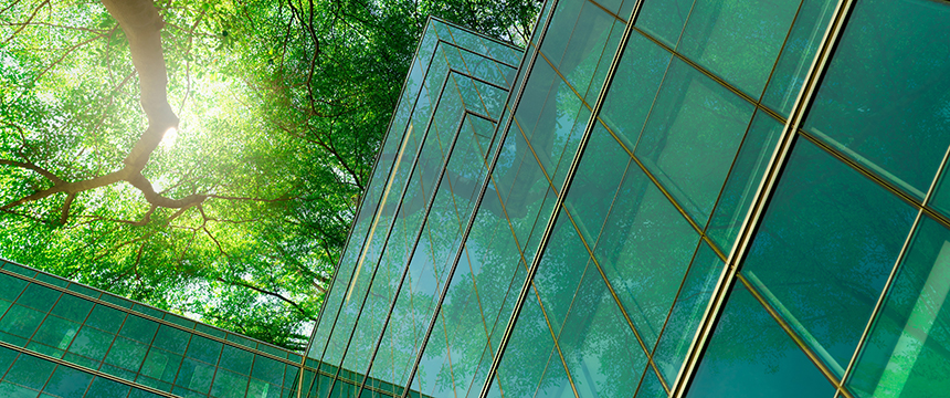 Glass buildings reflect green trees and sunlight, blending natural foliage with modern architecture—an inspiring view for a corporate law office or lawyers in Chicago seeking a dynamic workspace.