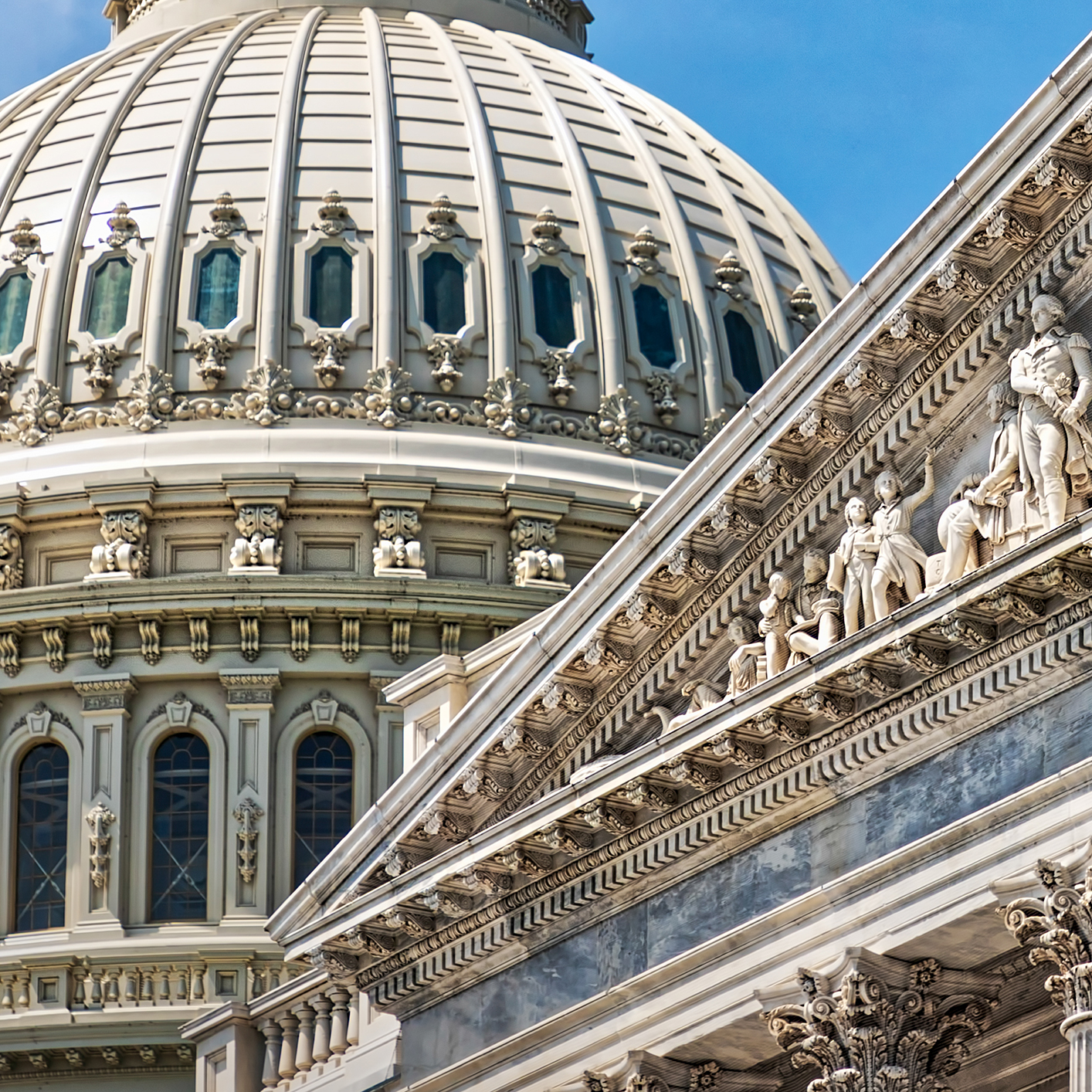 Close-up view of the U.S. Capitol dome and part of the facade, showcasing ornate architectural details—an inspiring symbol for law offices and litigation support professionals against a bright blue sky.