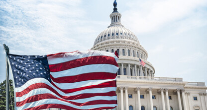 The American flag waves in front of the United States Capitol building under a partly cloudy sky, symbolizing justice and inspiring Chicago lawyers and law offices dedicated to litigation support.