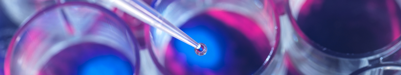 Close-up of a pipette dispensing liquid into a petri dish or laboratory container under blue and pink lighting, capturing the precision essential for research in fields like intellectual property law.