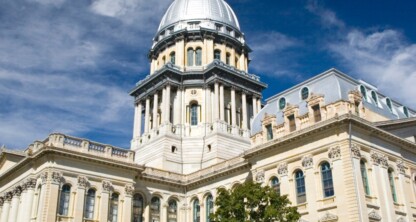A classical-style government building with a large central dome, ornate columns, and detailed stonework—an impressive setting for a prestigious corporate law office under a blue sky with clouds.