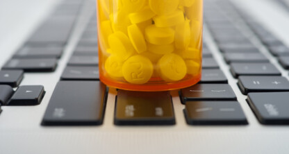 Un frasco de pastillas amarillas descansa sobre el teclado de un ordenador, lo que da una idea de las largas noches de trabajo y la dedicación de los abogados de Chicago.