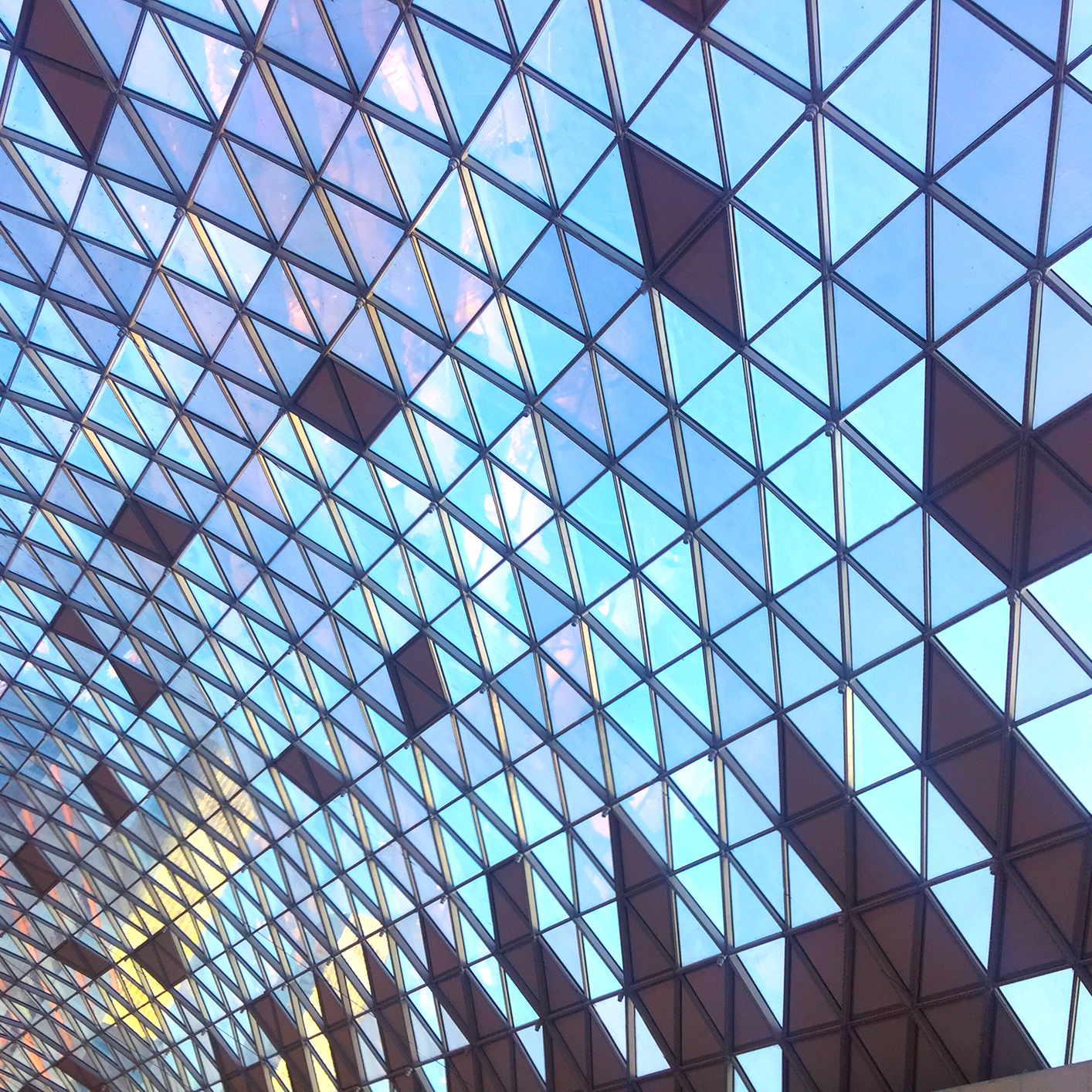 Geometric glass ceiling with triangular and diamond-shaped patterns, allowing natural light to enter the law offices below—an inspiring setting for Chicago lawyers and litigation support teams.