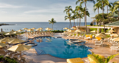 Resort pool area with yellow umbrellas, lounge chairs, and palm trees overlooking the ocean under a clear sky—a perfect escape for lawyers in Chicago seeking relaxation after busy days.