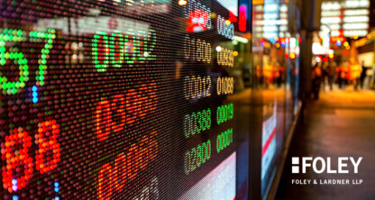 Digital stock ticker displays numbers and prices in bright colors on a city street, with the Foley & Lardner LLP corporate law office logo visible in the lower right corner.