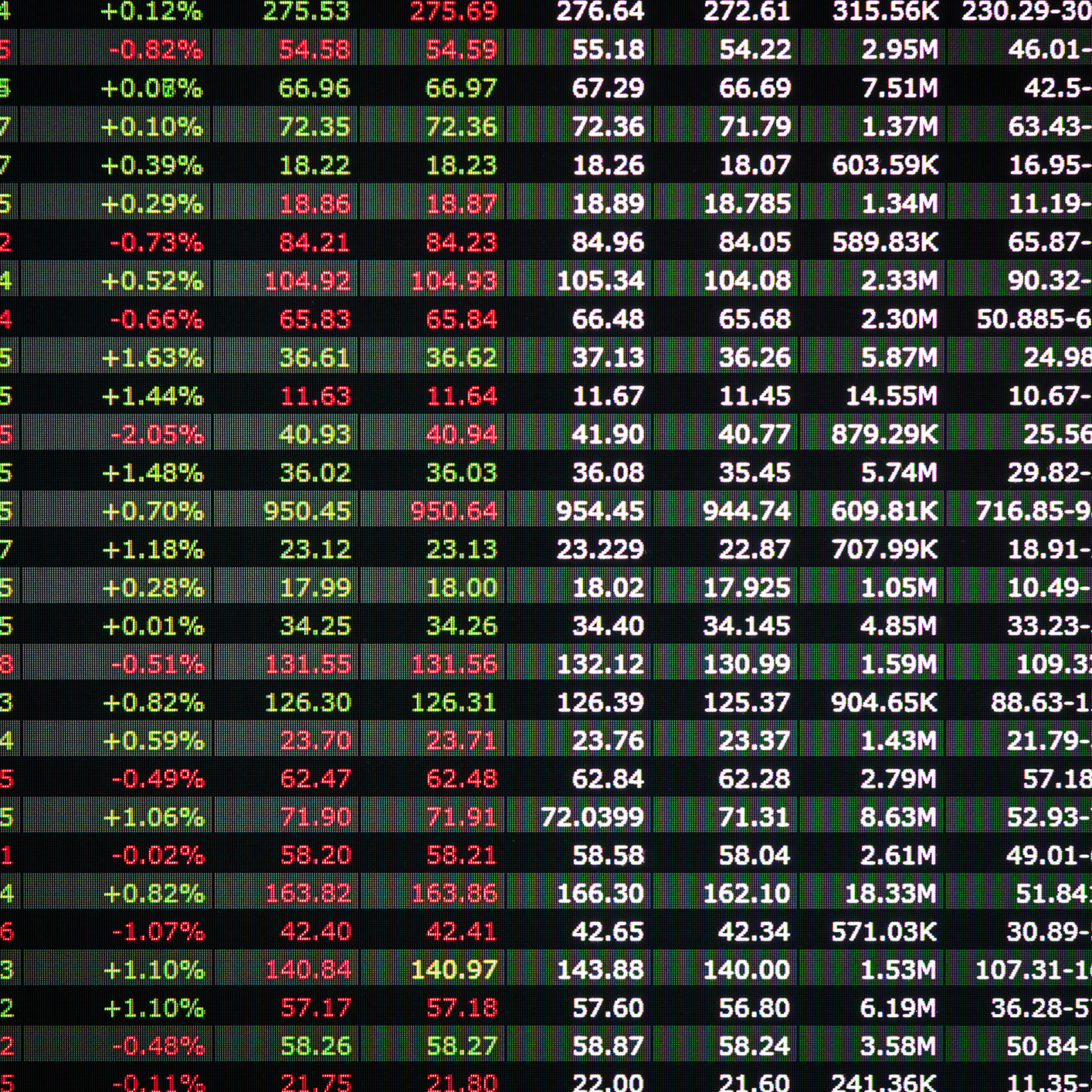 A digital screen displays a grid of stock market data with numbers in red and green, commonly seen in corporate law offices or among Chicago lawyers tracking financial trends for their clients.
