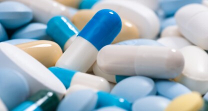A close-up of various pills and capsules in blue, white, yellow, and beige colors, scattered and overlapping each other—an image sometimes referenced by Chicago lawyers specializing in intellectual property law.