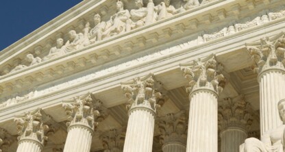 The image shows the facade of the United States Supreme Court building, featuring Corinthian columns and sculpted figures above the entrance—a symbol of justice often referenced by Chicago lawyers specializing in intellectual property law.