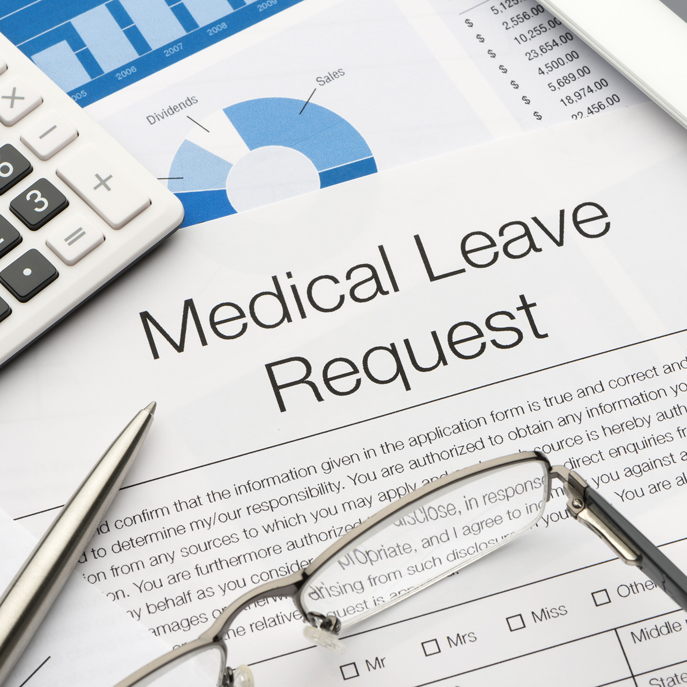 A medical leave request form on a desk at a corporate law office, with a pen, glasses, calculator, and financial documents in the background.