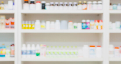 Blurred image of pharmacy shelves stocked with various bottles and boxes of medication and health products, ideal for chicago lawyers seeking visuals related to intellectual property law or litigation support in the pharmaceutical industry.