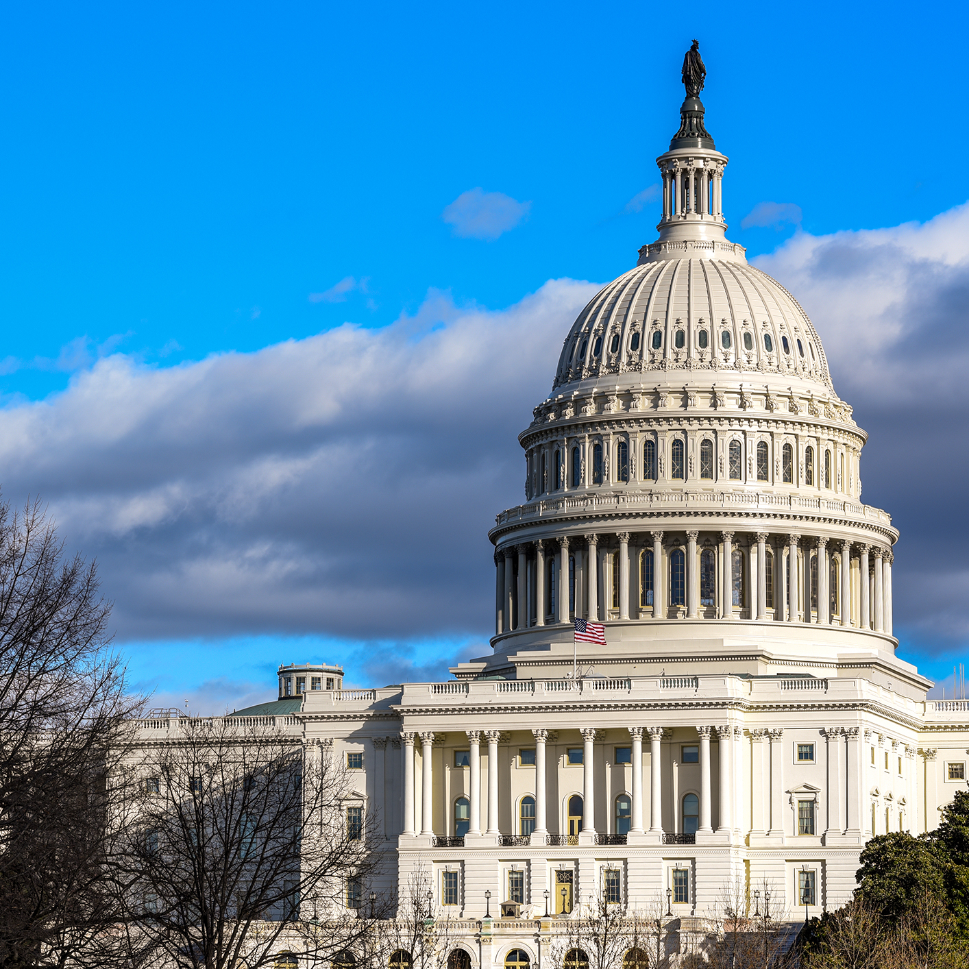 The United States Capitol building in Washington, D.C., stands tall beneath a clear blue sky and some clouds, symbolizing the foundation of the nation’s law offices and intellectual property law.