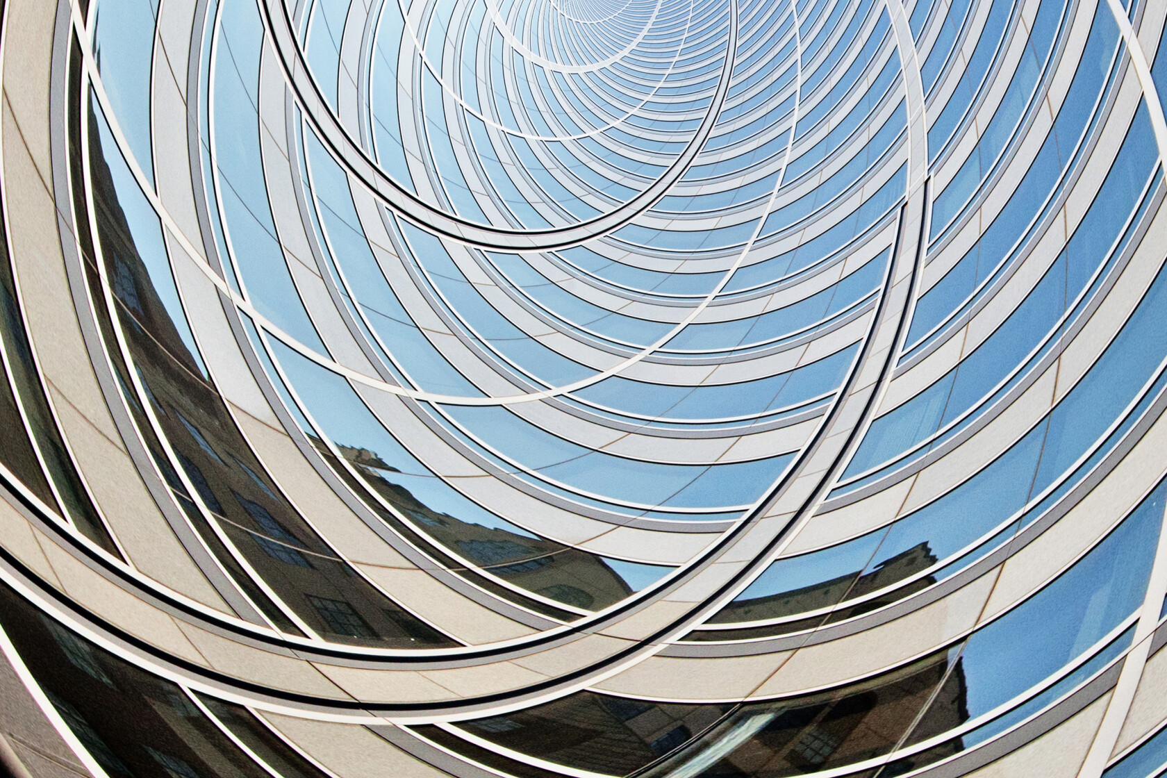 A close-up view of a modern glass building with curved, concentric architectural lines reflects the blue sky—an iconic location for a corporate law office or Chicago lawyers specializing in litigation support.