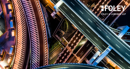 Aerial view of a complex multi-level highway interchange at night, with illuminated roads and lanes, featuring the Foley &amp; Lardner LLP logo in the upper right corner, highlighting a leading corporate law office of Chicago lawyers.