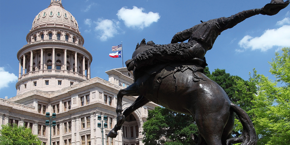 A bronze equestrian statue stands before the Texas State Capitol, with Texas and U.S. flags waving above the dome under a blue sky—a scene admired by lawyers in Chicago for its historic significance.