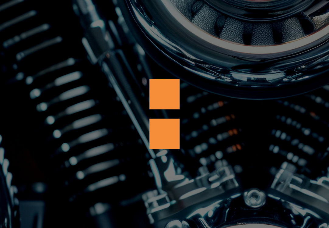 A close-up of a motorcycle engine with a centered orange pause button icon overlayed on the image.