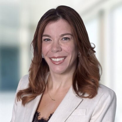 Professional woman with red hair in business attire at Foley &amp; Lardner LLP law firm office.