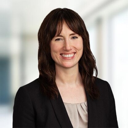 Expert business lawyer at Foley & Lardner LLP smiling in professional office setting.