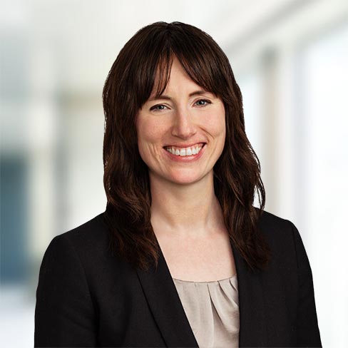 Expert business lawyer at Foley & Lardner LLP smiling in professional office setting.